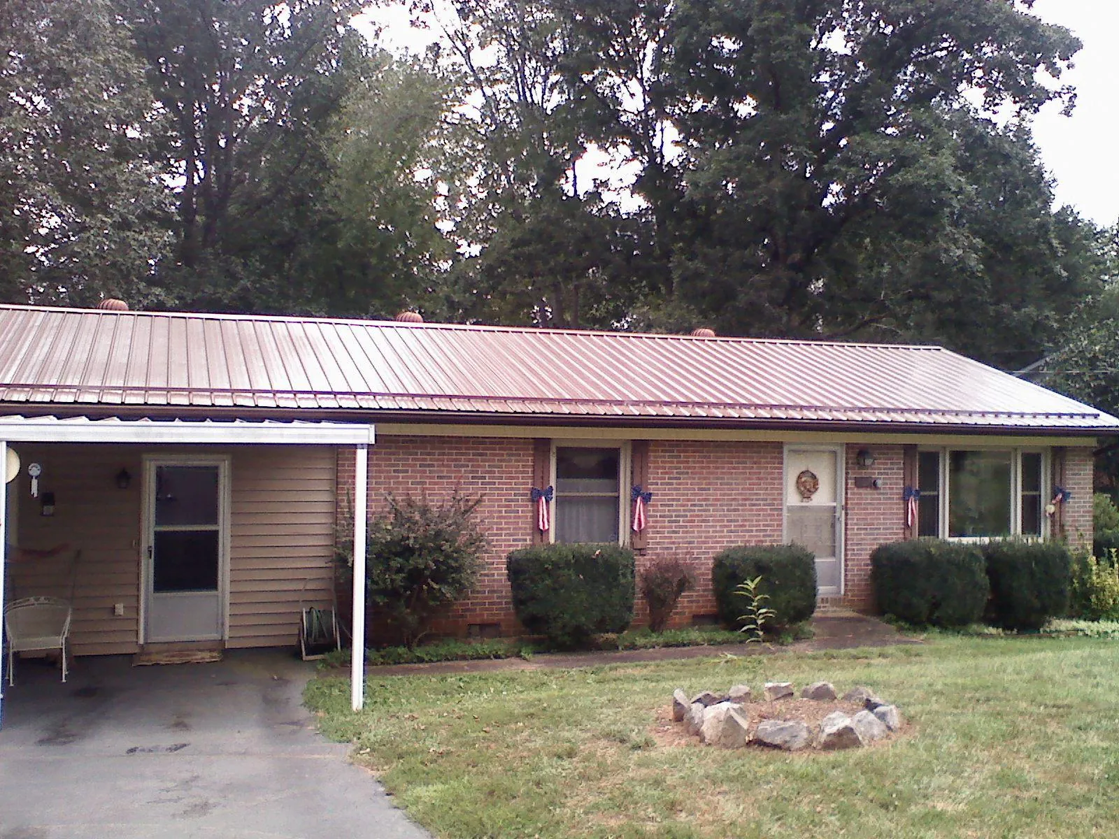 Bronze metal roof and carport on a brick ranch home — Roof Repair work by our crew in Loxahatchee