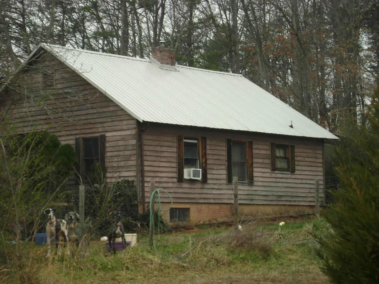 White metal roof on an old wood sided farmhouse, from a Metal Roof Installation job in Loxahatchee